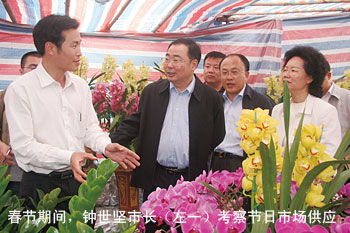 年初，钟世坚市长（左二）看望花农