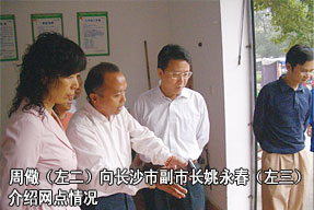 周儆（左二）向长沙市副市长姚永春（左三）介绍网点情况