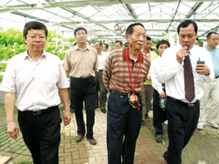 百色人大主任、市委书记刘正东（左一），市长谢泽宇（后排左一）陪同袁隆平院士（左二）考察园区工作
