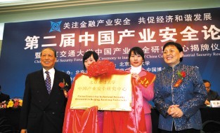 图为11月24日，全国人大常委会副委员长成思危（左一）与全国政协副主席张梅颖（右一）为“北京交通大学中国产业安全研究中心”揭牌。