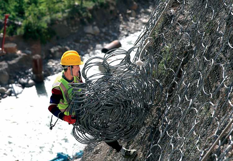 工人在陡峭的岩壁上悬挂导石网.jpg